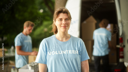 Portrait of a Happy Helpful Young Female Volunteer. Beautiful Caucasian Brunette Smiling, Looking at Camera. Humanitarian Aid, Donations Center and Volunteering Concept.