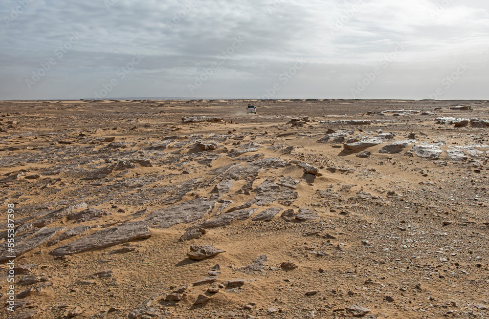 Barren desert landscape in hot climate with off-road vehicle - obrazy, fototapety, plakaty 