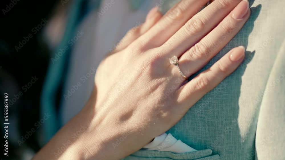 A bride's hand with a beautiful ring goes through the groom's chest. Close-up slow motion video shooting A bride's hand with a beautiful ring goes through the groom's chest. Close-up slow motion video shooting