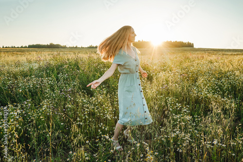 Woman dance in the field on sunset.