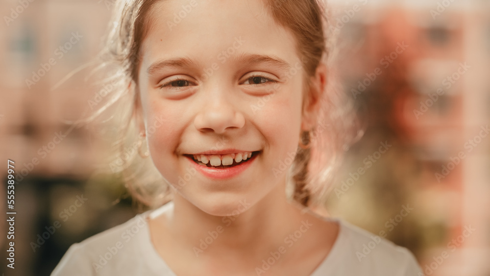 Close Up Portrait of an Adorable Little Girl with Brown Eyes and Hair Looking at Camera, Smiling Happily. Smart Talented Girl Laughing and Having Fun at Home. Soft Bokeh Background. Close Up Portrait of an Adorable Little Girl with Brown Eyes and Hair Looking at Camera, Smiling Happily. Smart Talented Girl Laughing and Having Fun at Home. Soft Bokeh Background.