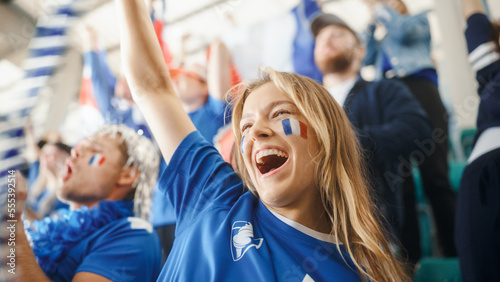Sport Stadium Big Event: Portrait of Beautiful Sports Fan Girl with French Flag Painted Face Cheering For Her Team to Win. Crowd of Fans Shout, Celebrate Scoring a Goal, Championship Victory