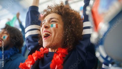 Sport Stadium Soccer Match: Portrait of Beautiful Bi Racial Fan Girl with Italian Flag Painted Face Cheering Team to Win, Beating Tambourine. Crowd Celebrate Goal, Championship Victory