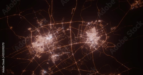 Buraydah and Unaizah (Saudi Arabia) aerial view at night. Top view on modern city with street lights. Camera is zooming out, rotating clockwise. Vertical video. The north is on the left side photo