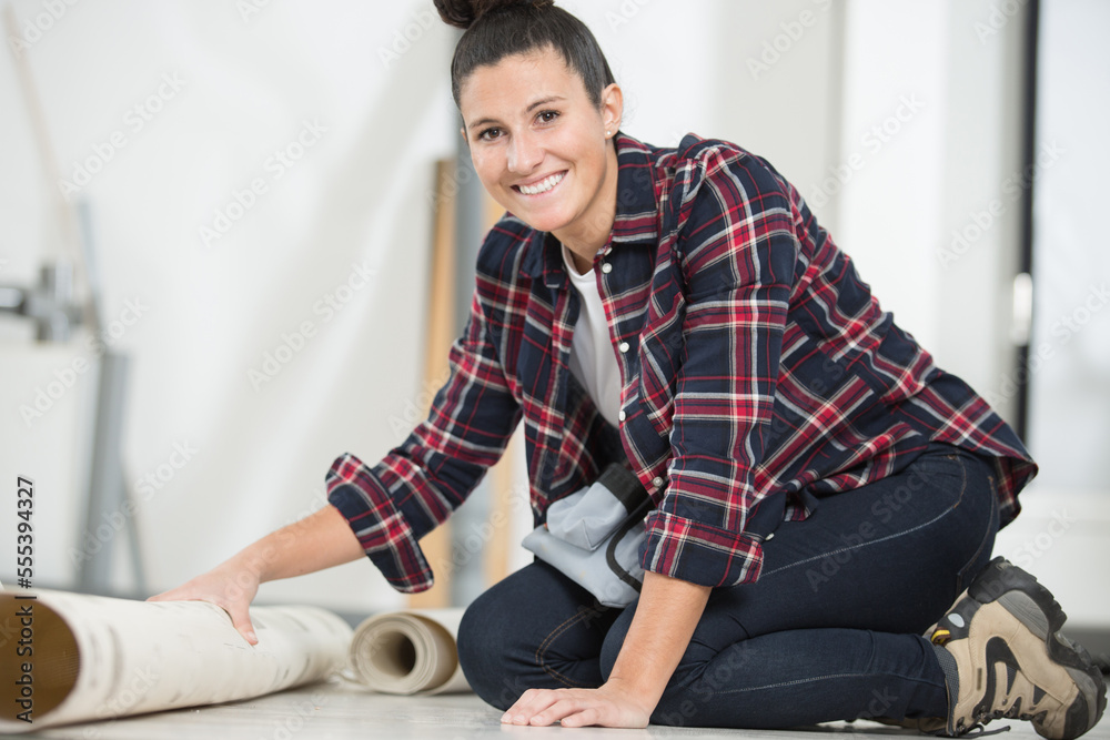 Fototapeta premium happy woman is unrolling a new carpet