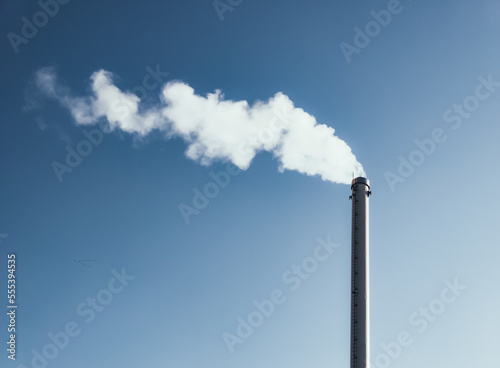 Factory chimney with smoke. Industrial pipe. Blue sky at sunny day. Air pollution/