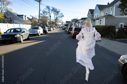 fashion portrait of non-binary person wearing white dress in suburbia photo