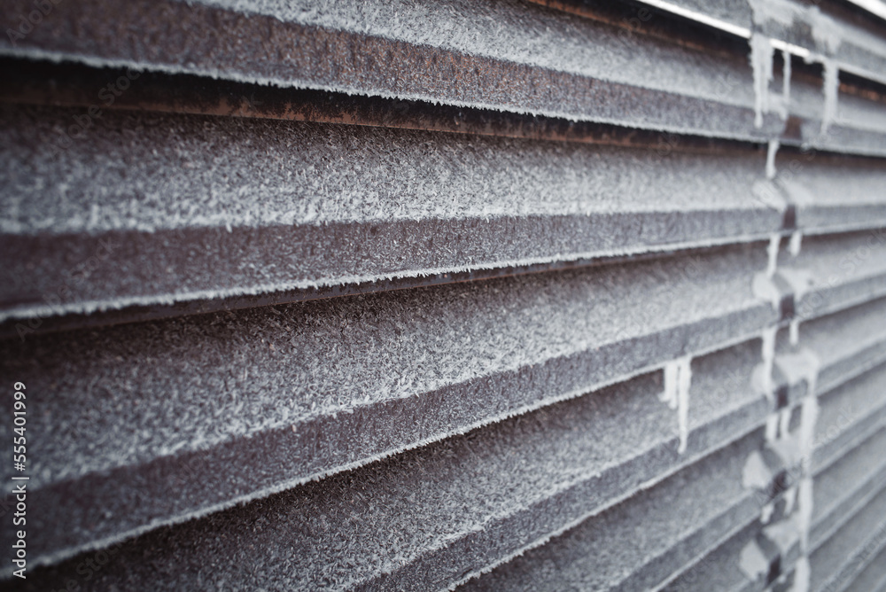 Brown metal fence covered with frost and ice crystals. Brown metal fence covered with frost and ice crystals.