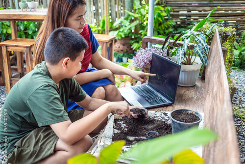 Portrait of a mother and son special moment. Gardening discovering and teaching learns to grow flowers in pots through online teaching leisure activity concept