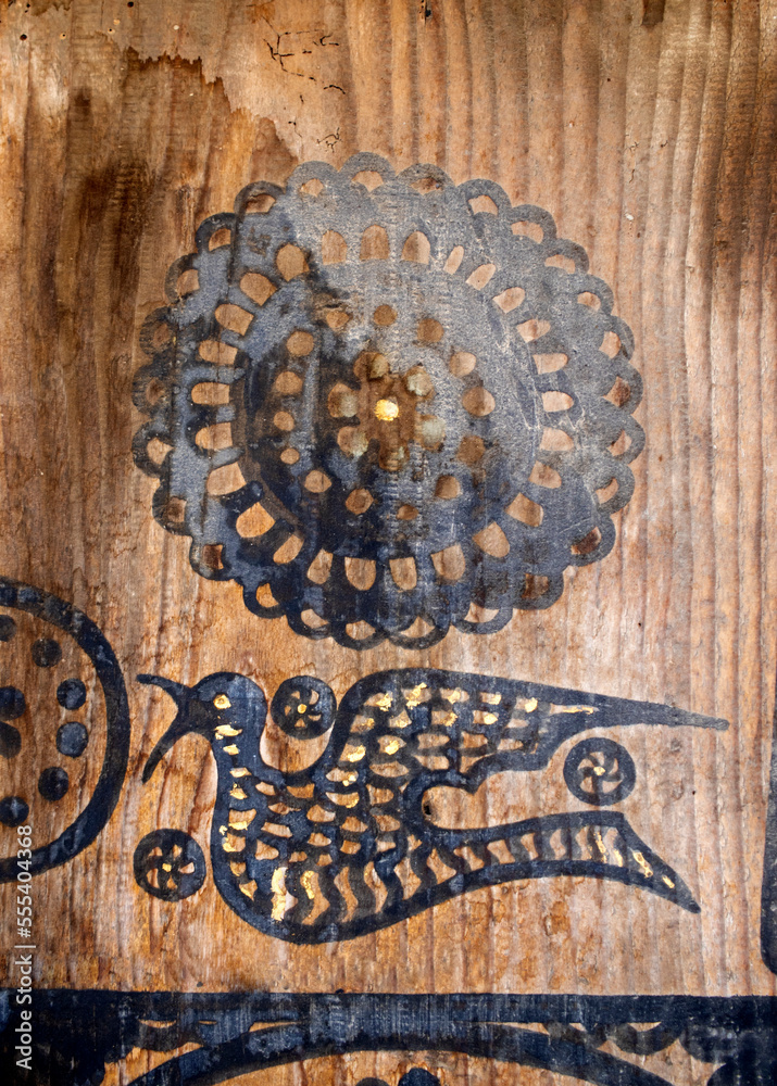 bird and geometric motifs on the old wooden door.