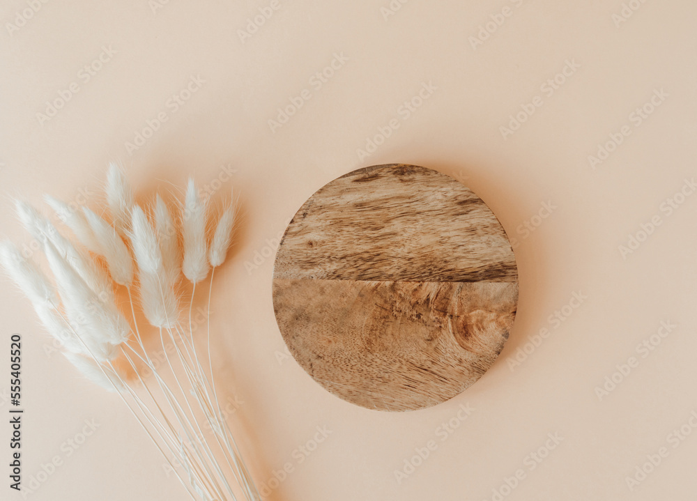 Φωτογραφία Wood brown round podium and bouquet of dry Lagurus on beige background