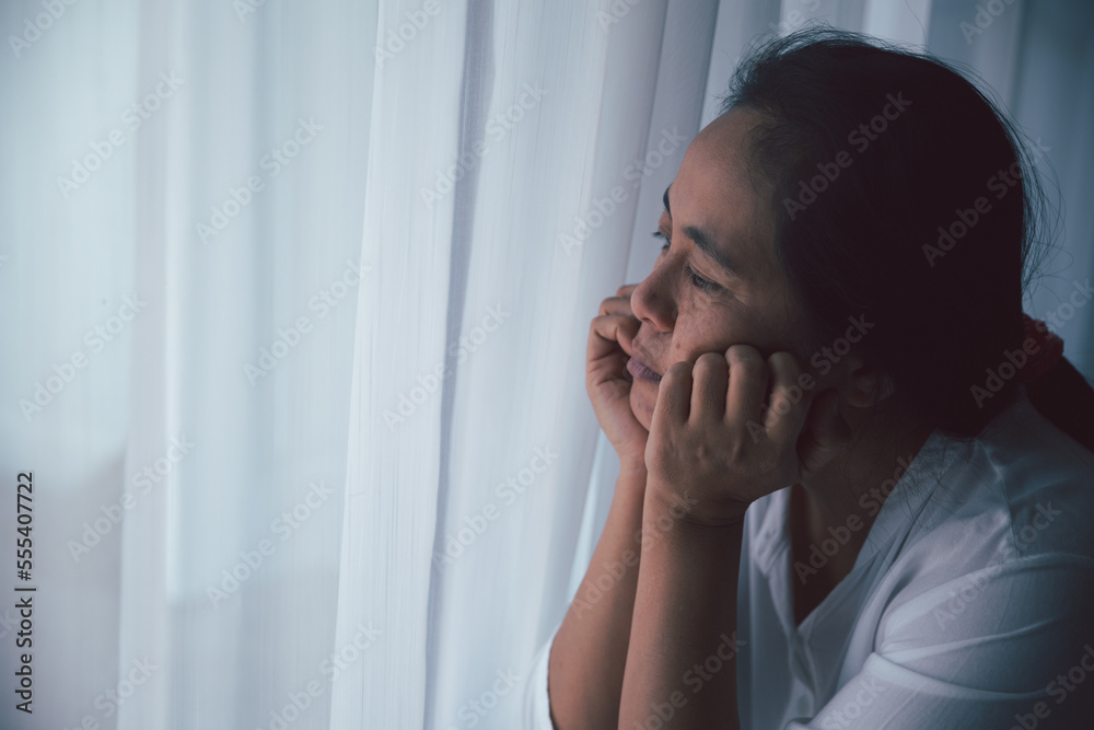 Schizophrenia with lonely and sad in mental health depression concept. Depressed woman sitting against floor at home with dark room feeling miserable. Women are depressed, fearful and unhappy. Schizophrenia with lonely and sad in mental health depression concept. Depressed woman sitting against floor at home with dark room feeling miserable. Women are depressed, fearful and unhappy.