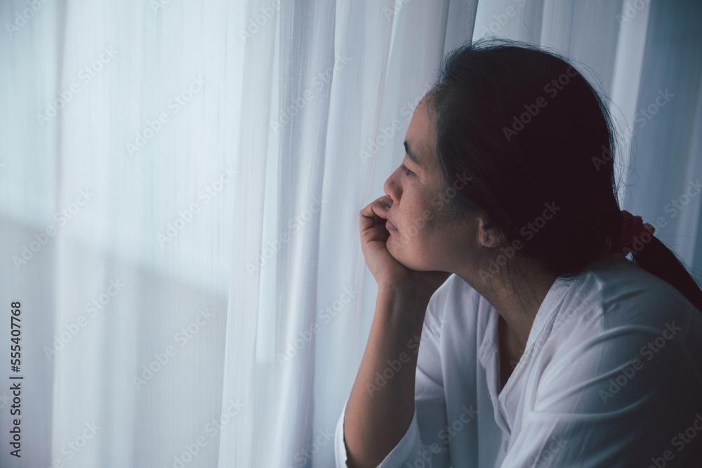 Schizophrenia with lonely and sad in mental health depression concept. Depressed woman sitting against floor at home with dark room feeling miserable. Women are depressed, fearful and unhappy. Schizophrenia with lonely and sad in mental health depression concept. Depressed woman sitting against floor at home with dark room feeling miserable. Women are depressed, fearful and unhappy.