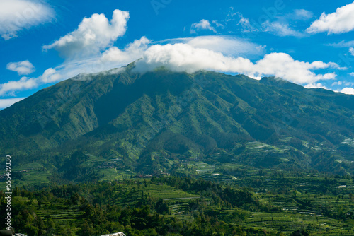 The beauty of Mount Merbabu seen from Ketep Pass, a mountain covered with green hills and blue sky and a few clouds that spoil the eyes of visitors