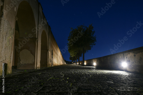 A narrow street along the walls of the castle of Baia in a night photo  Italy.