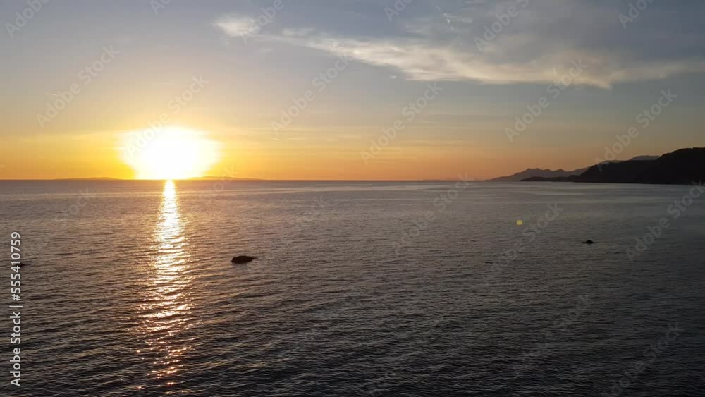 Sunset on the horizon over the Mediterranean Sea viewed from the top of a cliff above a sandy beach Sunset on the horizon over the Mediterranean Sea viewed from the top of a cliff above a sandy beach