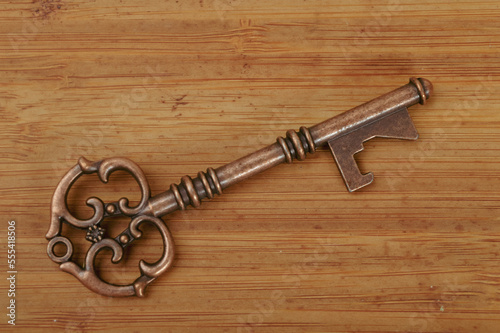 Vintage and retro key isolated on a wooden background.