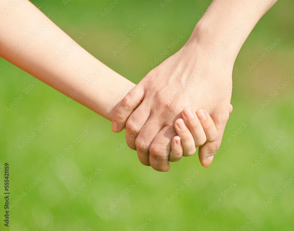 Mother holding a hand of his son in summer day outdoors Mother holding a hand of his son in summer day outdoors