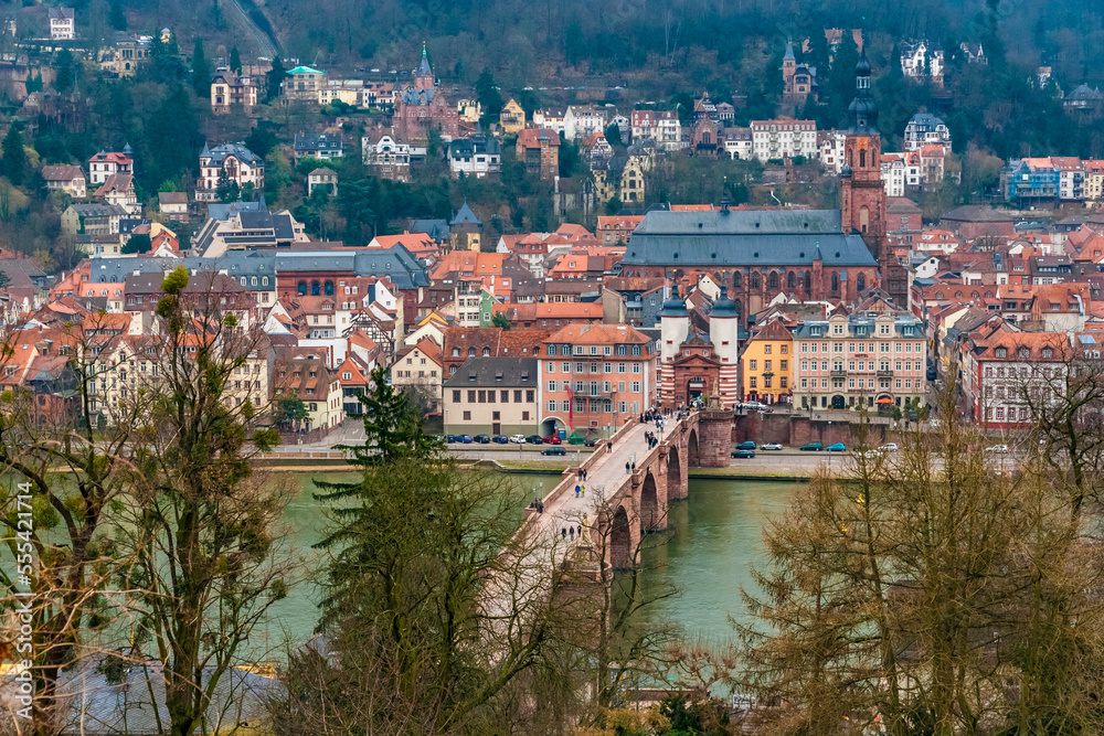 Picturesque view of the old town centre of Heidelberg, Germany, with the bridge Karl-Theodor-Brücke including the famous bridge gate Brückentor and behind stands the church Heiliggeistkirche.
