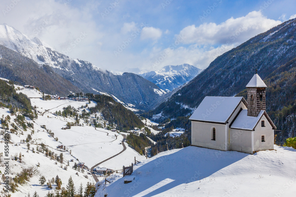Church on a hill in a snowy alp valley