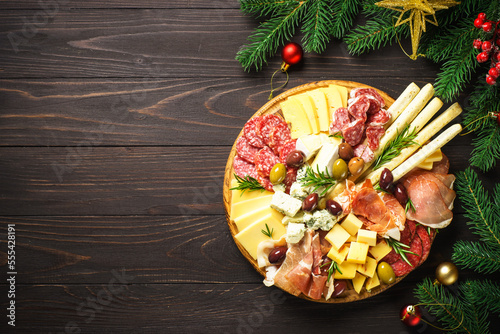 Antipasto platter with jamon, salami and cheese assortment with christmas decorations.