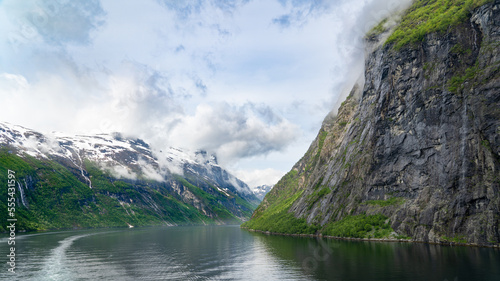 Beautiful landscape with snowy mountain peaks and waterfalls in Geiranger fjord, Norway