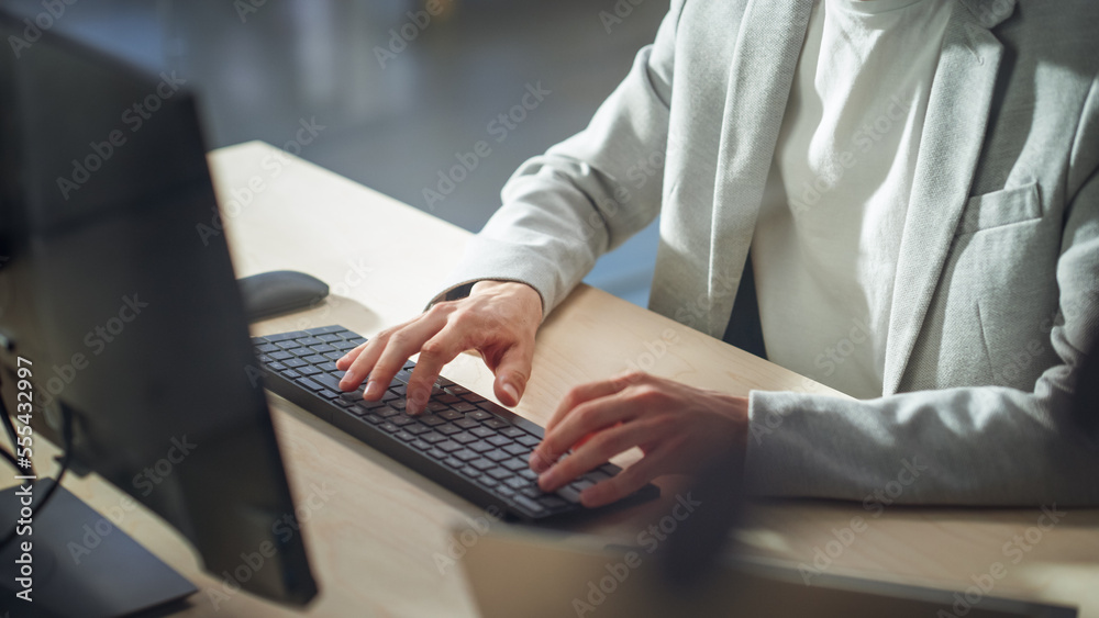 Stylish Male Employee in Gray Casual Blazer Working on Computer in Office During a Sunny Day. Close Up on Hands of a Manager Typing Texts on a Keyboard, Writing Emails and Using Internet. Stylish Male Employee in Gray Casual Blazer Working on Computer in Office During a Sunny Day. Close Up on Hands of a Manager Typing Texts on a Keyboard, Writing Emails and Using Internet.
