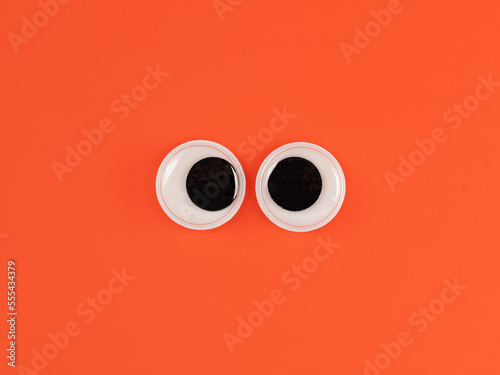 Cute googly eyes funny Isolated on bright orange background copy space logo