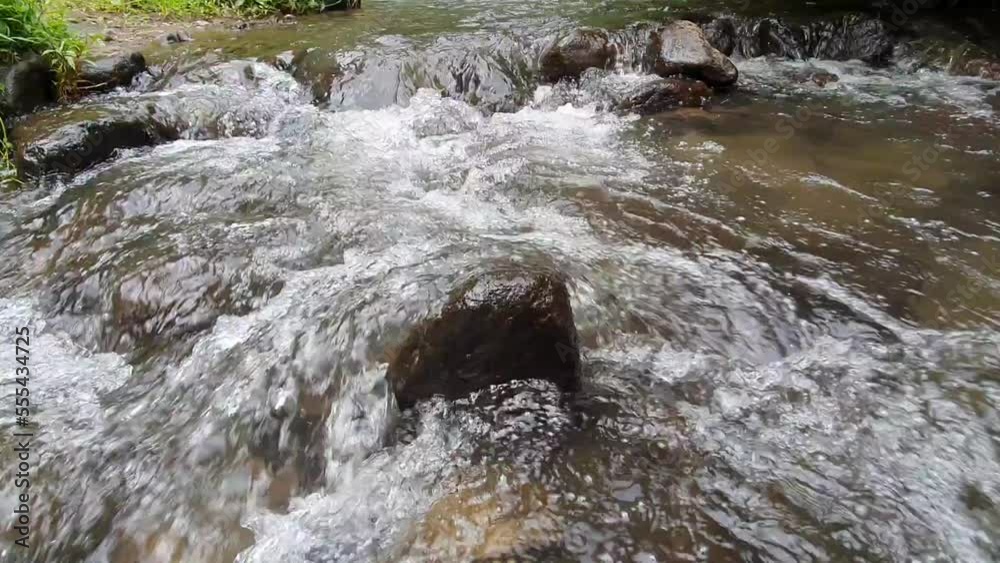 Water flowing over river stone in a stream or river Water flowing over river stone in a stream or river