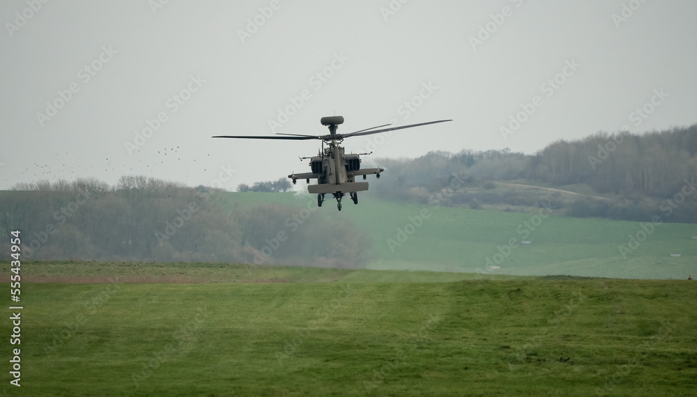 close-up tail view of British army Boeing Apache Attack helicopter (AH-64E ZM722 ArmyAir606) in a static hover, Wiltshire UK close-up tail view of British army Boeing Apache Attack helicopter (AH-64E ZM722 ArmyAir606) in a static hover, Wiltshire UK