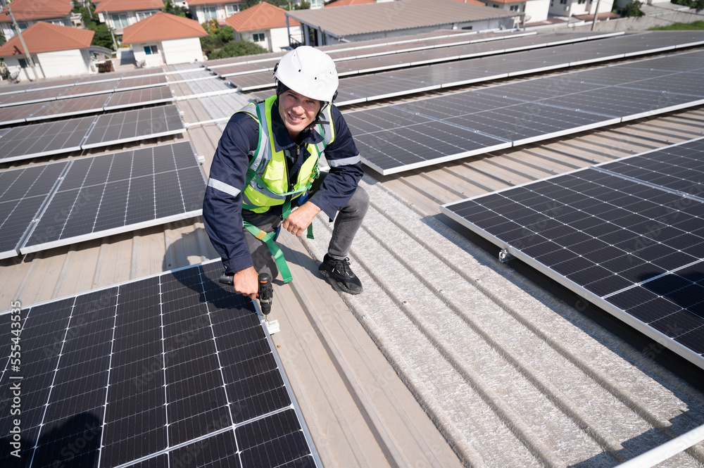 Caucasian engineer man use electric screwdriver working with solar panel on roof factory Caucasian engineer man use electric screwdriver working with solar panel on roof factory