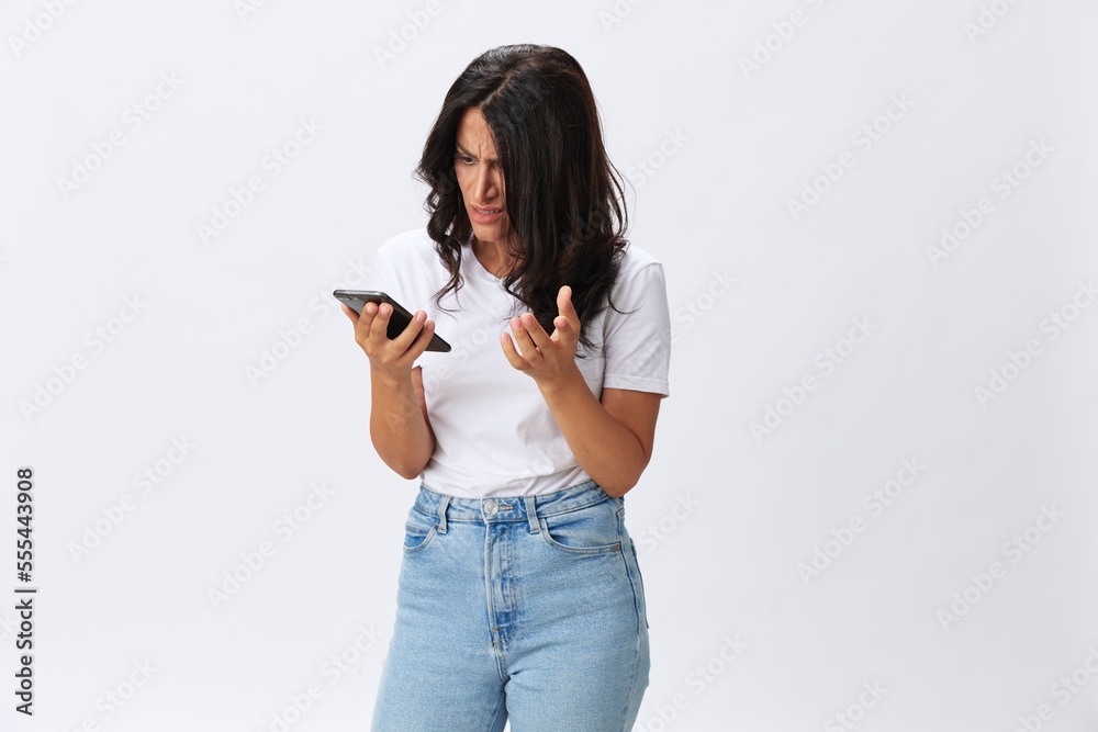 Woman blogger with a phone in her hands photo content, video call, selfie smile with teeth in a white t-shirt on a white background, copy space, emotions and gestures signals Woman blogger with a phone in her hands photo content, video call, selfie smile with teeth in a white t-shirt on a white background, copy space, emotions and gestures signals