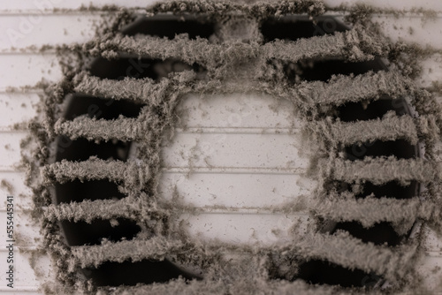 Very dirty and dusty white plastic air vent. The ventilation shaft in the apartment. Dirty air filter. The concept of house cleaning