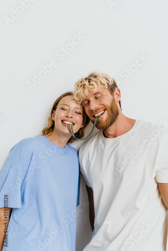 White blond excited couple eating candy while making fun together