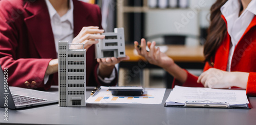 Discussion with a real estate agent  House model with agent and customer discussing for the contract to buy  get insurance or loan real estate or property.