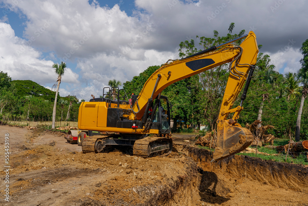 Excavator at earthworks. The excavator prepares the site for the road. Excavator at earthworks. The excavator prepares the site for the road.