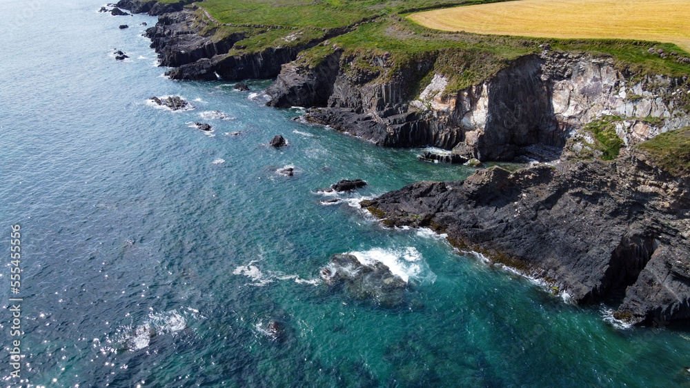 Seaside landscape of the south of Ireland. Picturesque coastal cliffs. The water of the Atlantic Ocean is turquoise. Aerial photo.