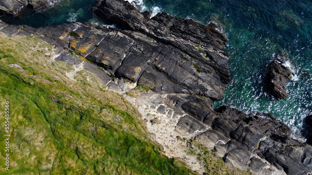 Dense thickets of grass on the shore. Grass-covered rocks on the Atlantic Ocean coast. Nature of Ireland, top view. Aerial photo. View from above. Dense thickets of grass on the shore. Grass-covered rocks on the Atlantic Ocean coast. Nature of Ireland, top view. Aerial photo. View from above.