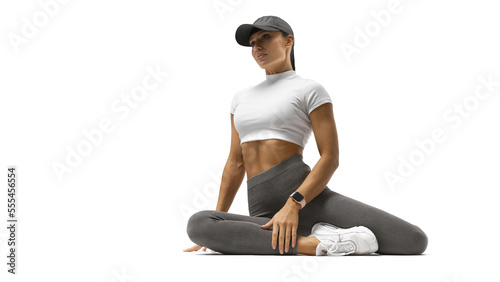 Fit woman sitting on floor. Sport. Fitness Girl With Strong Muscular Body In Fashion Sporty After Doing Flexibility Exercise. Female Bodybuilder photo