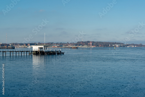 Gefrorenes Wasser in der Kieler Förde am Nordhafen im Vordergrund ein Bootshaus mit Steg © penofoto.de