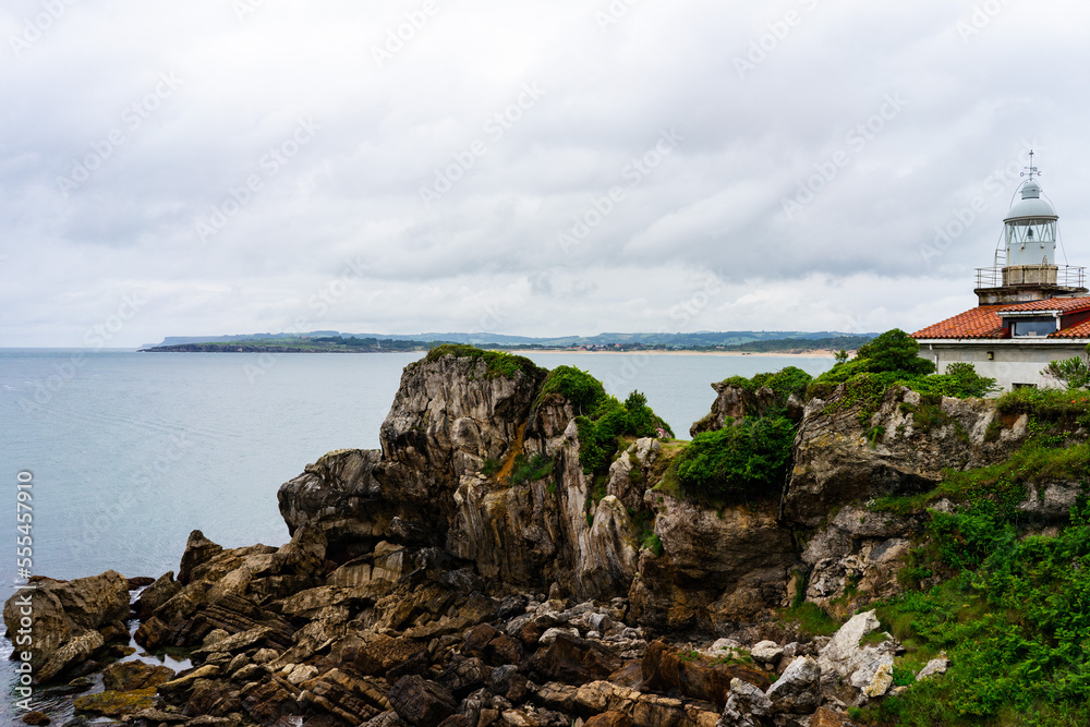 Empty cliff with island in the background of the sea under cloudy day, Spain