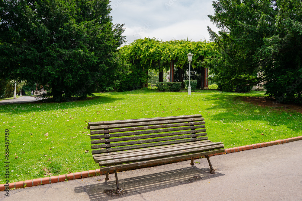 An empty bench in a middle of a green park, Spain An empty bench in a middle of a green park, Spain