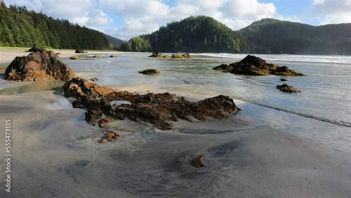 Sandy beach on Pacific Ocean Coast View. Sunny Blue Sky. San Josef Bay, Cape Scott Provincial Park, Northern Vancouver Island, BC, Canada. Canadian Nature Background. Cinematic 4k Slow Motion