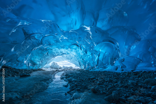 Blue glacial ice is exposed inside an ice cave at the terminus of Mendenhall Glacier, Mendenhall Lake, Tongass National Forest; Alaska, United States of America photo
