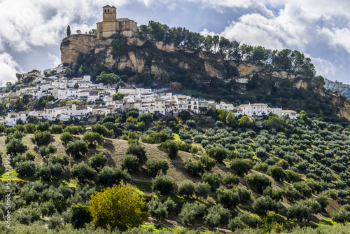Ruins of a Moorish castle on a hilltop with houses and an olive grove filling the hillside; Montefrio, Province of Granada, Spain photo
