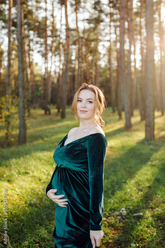Pregnant happy young woman walking outdoors in forest Pregnant happy young woman walking outdoors in forest