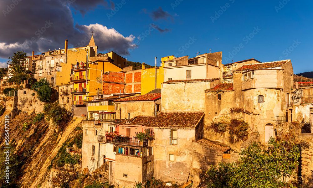 old mediterranean mountain dense town with levels of yellow houses and terraces on a mountain in evening light, vintage european village on a rock