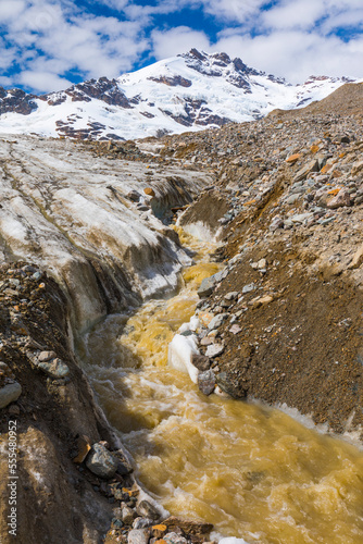 A meltwater stream flows down Castner Glacier with Mount Silvertip rising in the background; Alaska, United States of America photo