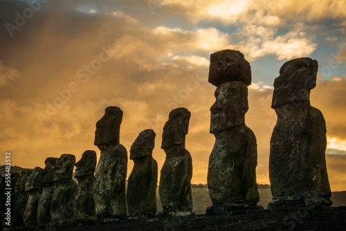 The fifteen moais of Tongariki close-up in decreasing perspective against a colourful sunrise; Easter Island, Chile photo