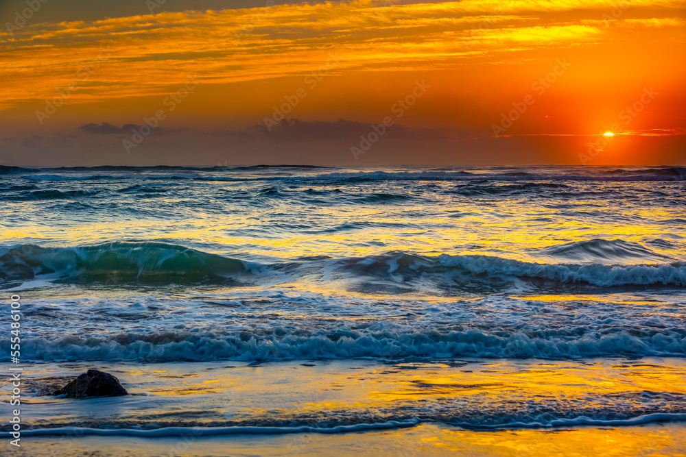 Bright golden sunrise over the Pacific Ocean; Kauai, Hawaii, United States of America Bright golden sunrise over the Pacific Ocean; Kauai, Hawaii, United States of America